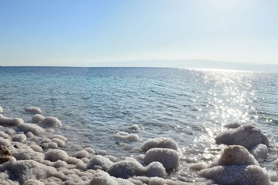 White salt crystals along the clear water's edge of the Dead Sea in Jordan