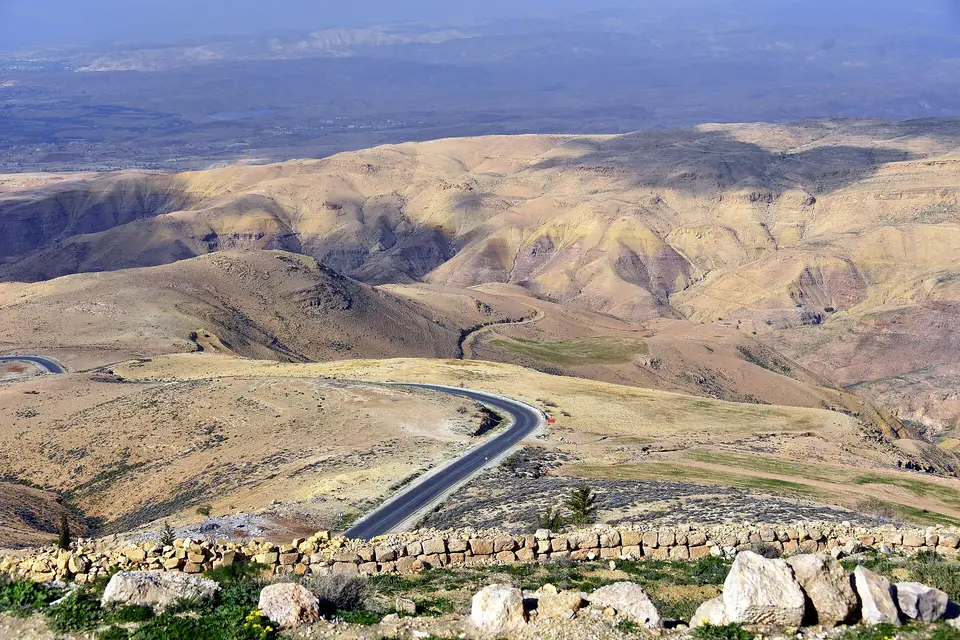 A road winding through dry hills below Mount Nebo above the Jordan Valley