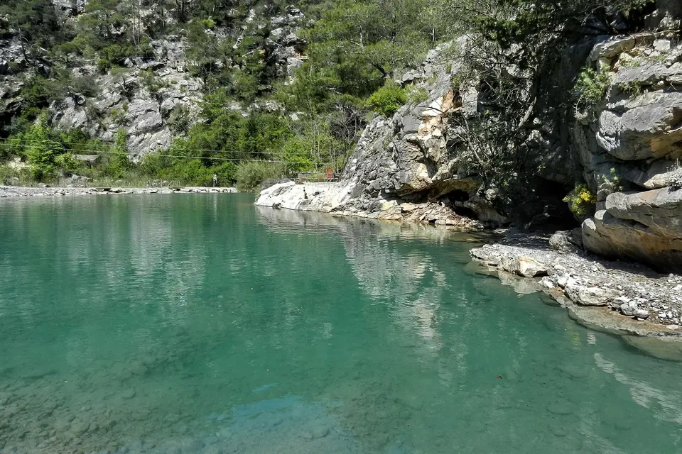 Turquoise water between pale limestone rocks and pine trees in Göynük Canyon near Kemer