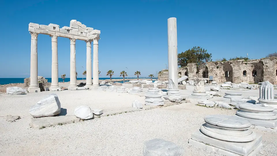 The standing columns of the Temple of Apollo among scattered ruins beside the sea at Side