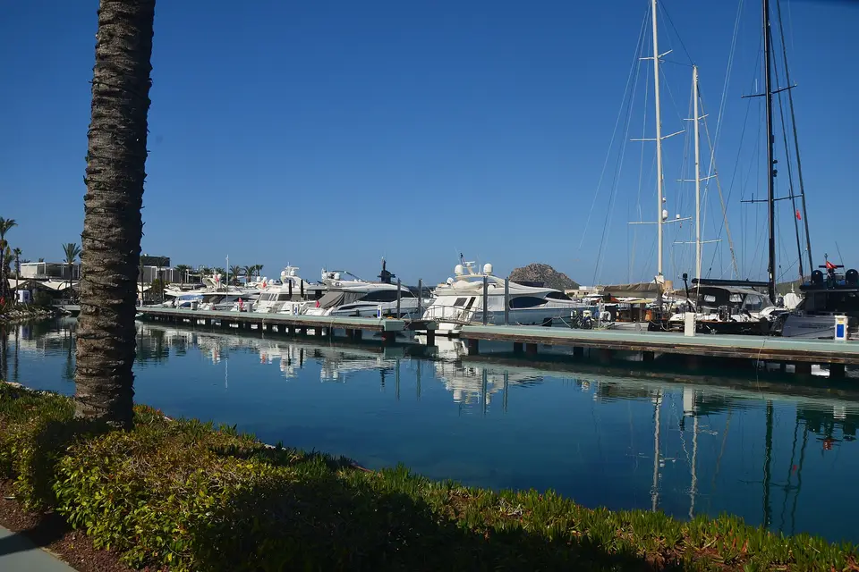 Yachts moored at Yalıkavak Marina reflected in calm water under a blue sky