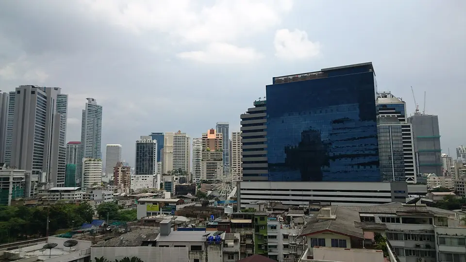 High-rise towers along Sukhumvit Road in Bangkok under a cloudy sky, seen from the EM Quarter