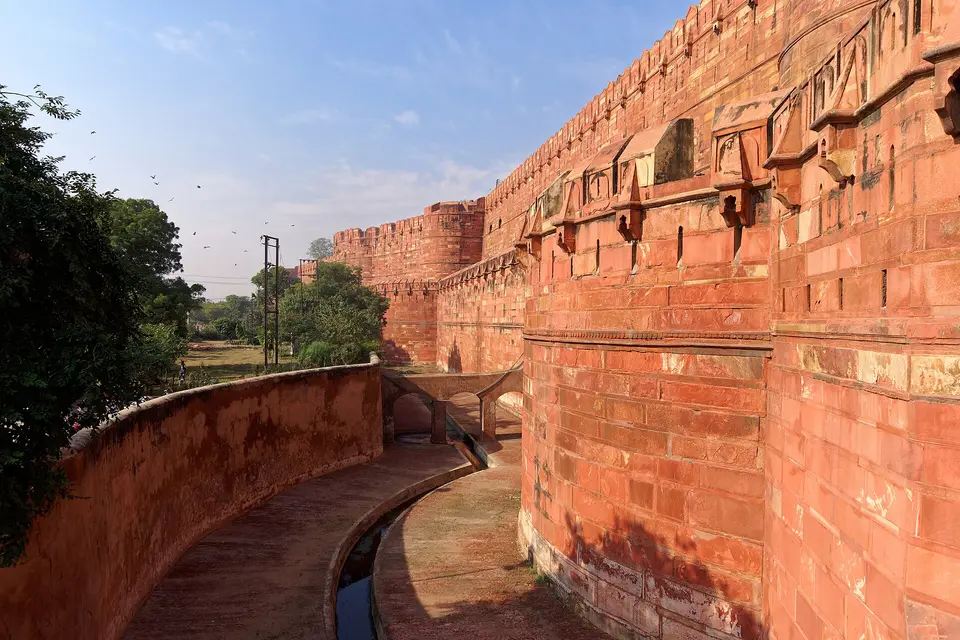 The red sandstone walls and dry moat of Agra Fort