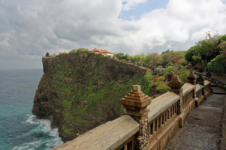 The clifftop shrines of Pura Luhur Uluwatu seen from the temple's stone walkway above the sea