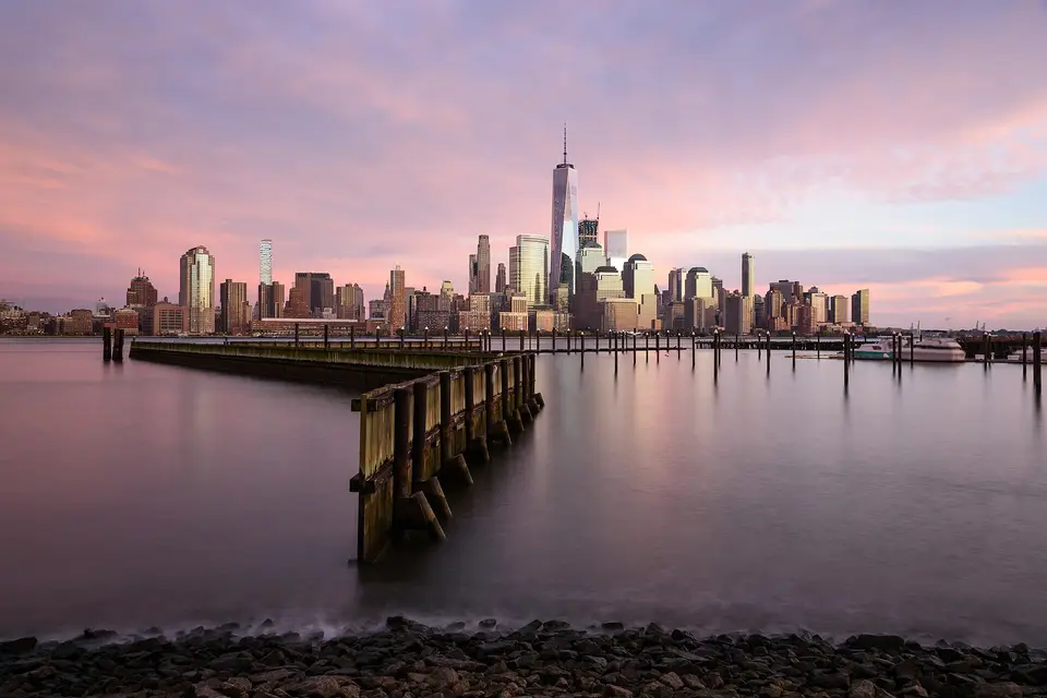 The Lower Manhattan skyline at dusk, seen across the Hudson River from Jersey City