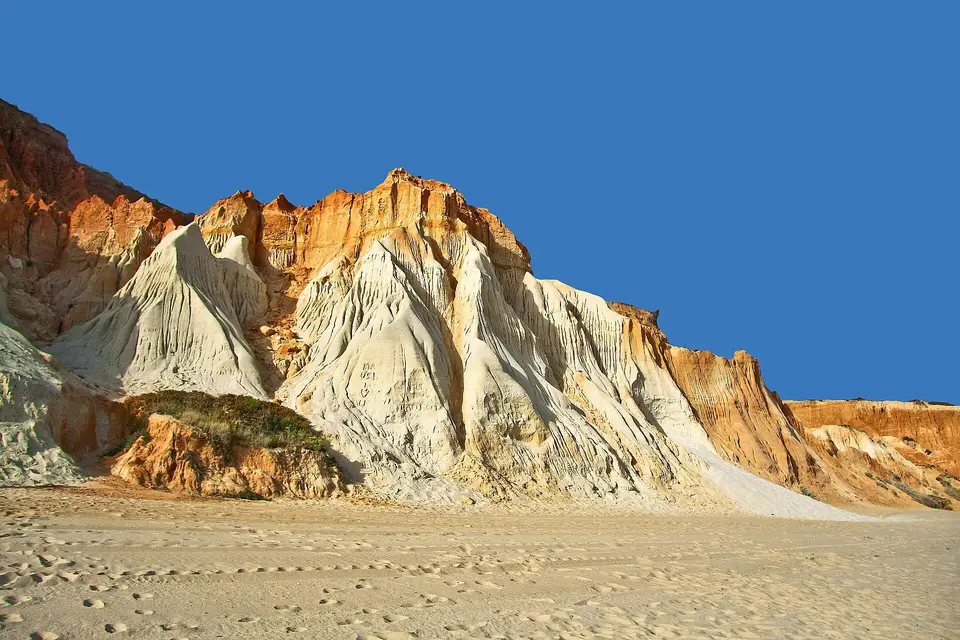 Weathered orange and white sandstone cliffs above the sand at Praia da Falésia near Albufeira