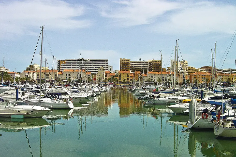 Yachts and sailing boats moored in Vilamoura Marina, with low-rise apartment buildings behind