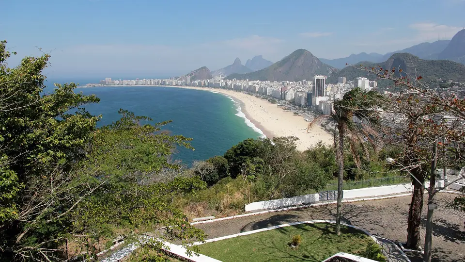 Copacabana beach and its curving shoreline seen from the Leme fort, with hills behind