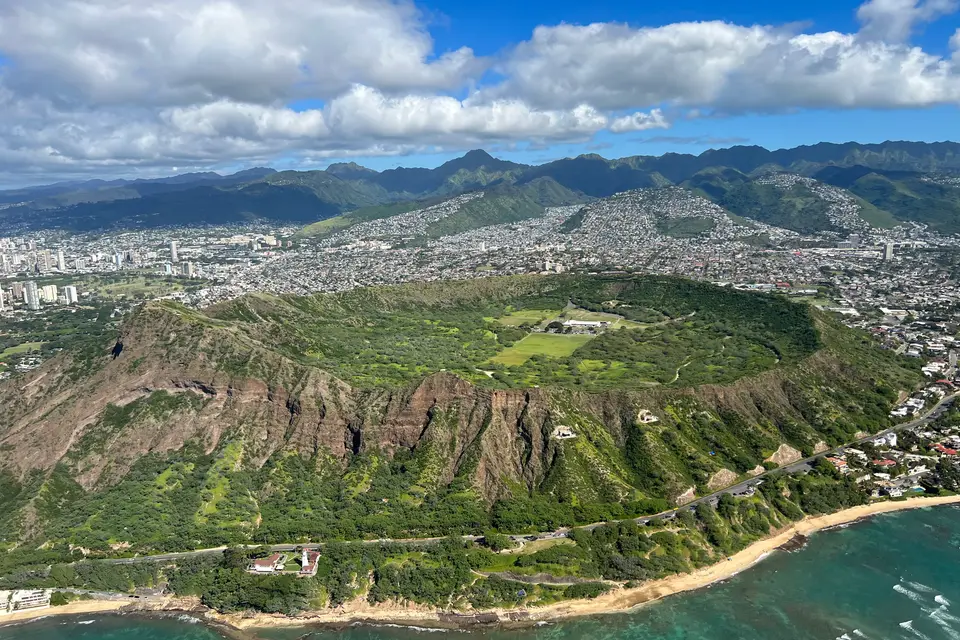Aerial view of the green Diamond Head crater above the coast east of Waikiki
