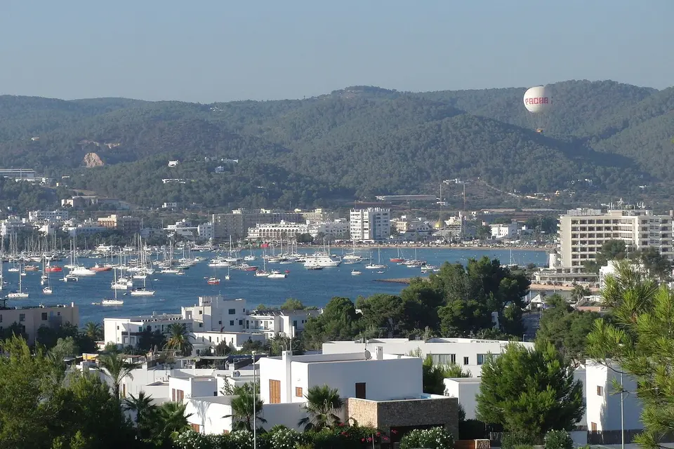 Yachts anchored in the bay of Sant Antoni de Portmany below wooded hills