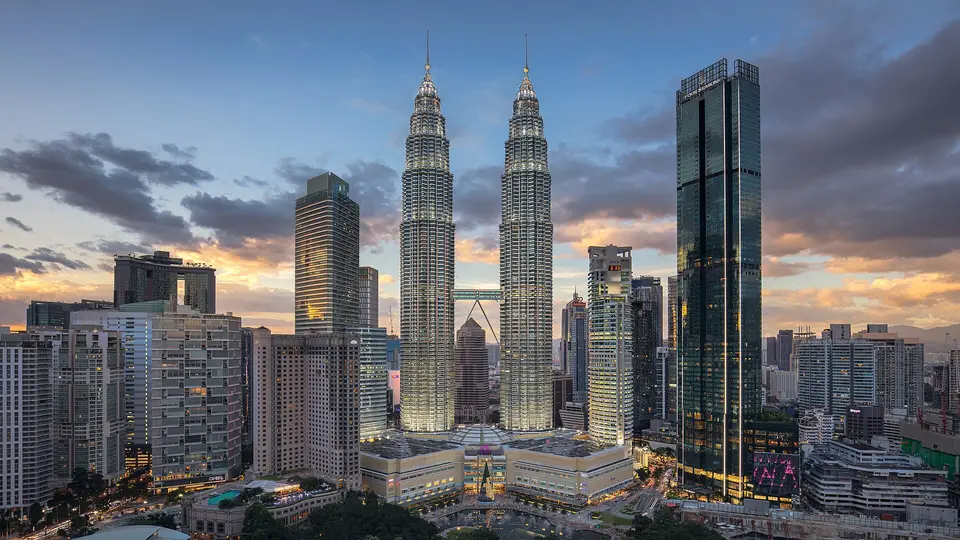 The Petronas Twin Towers rising above the Kuala Lumpur city centre at sunset