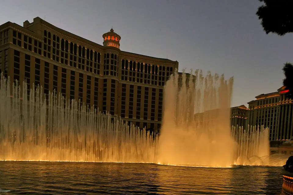 The Bellagio fountains lit gold at dusk in front of the hotel on the Las Vegas Strip