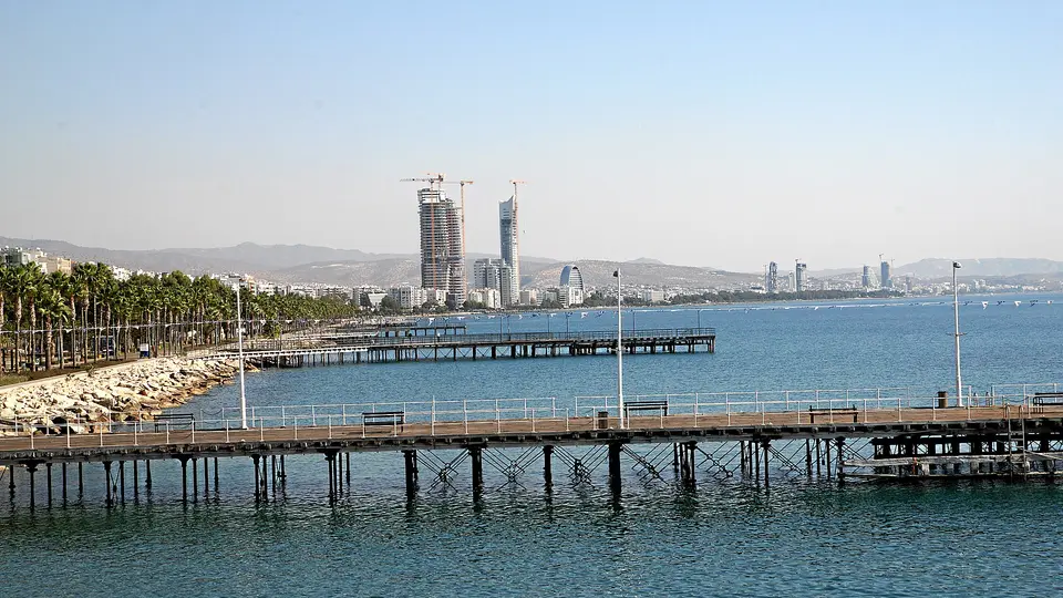 Wooden piers off the Limassol seafront with the city's new towers along the bay