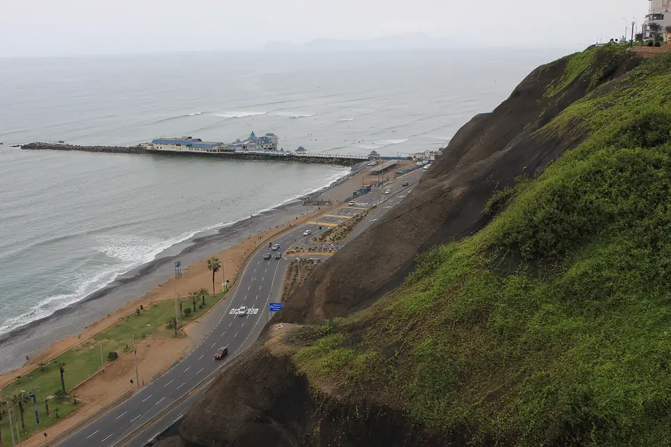 The Costa Verde coast road below the Miraflores cliffs, with a restaurant pier in the Pacific