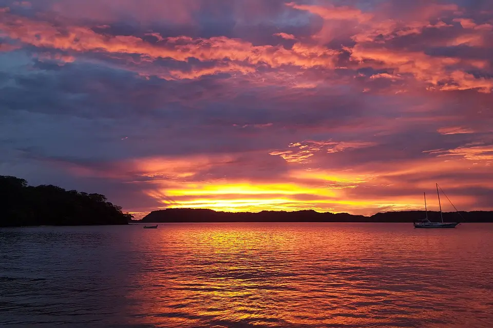 Sunset over Bahía Culebra with a moored sailing boat and the wooded Papagayo shoreline