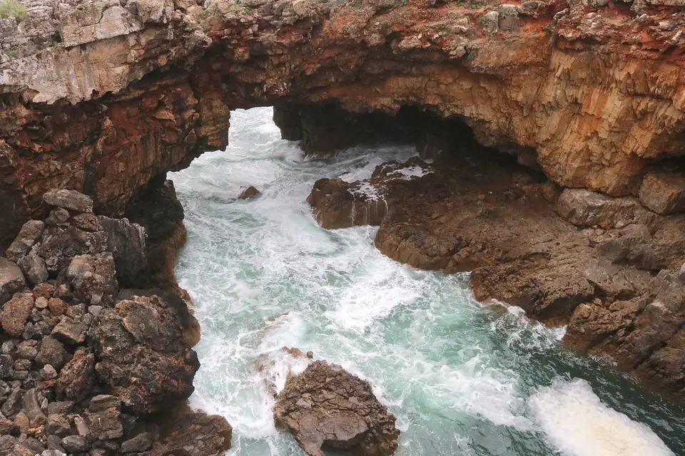 Waves breaking through the rock arch of Boca do Inferno near Cascais