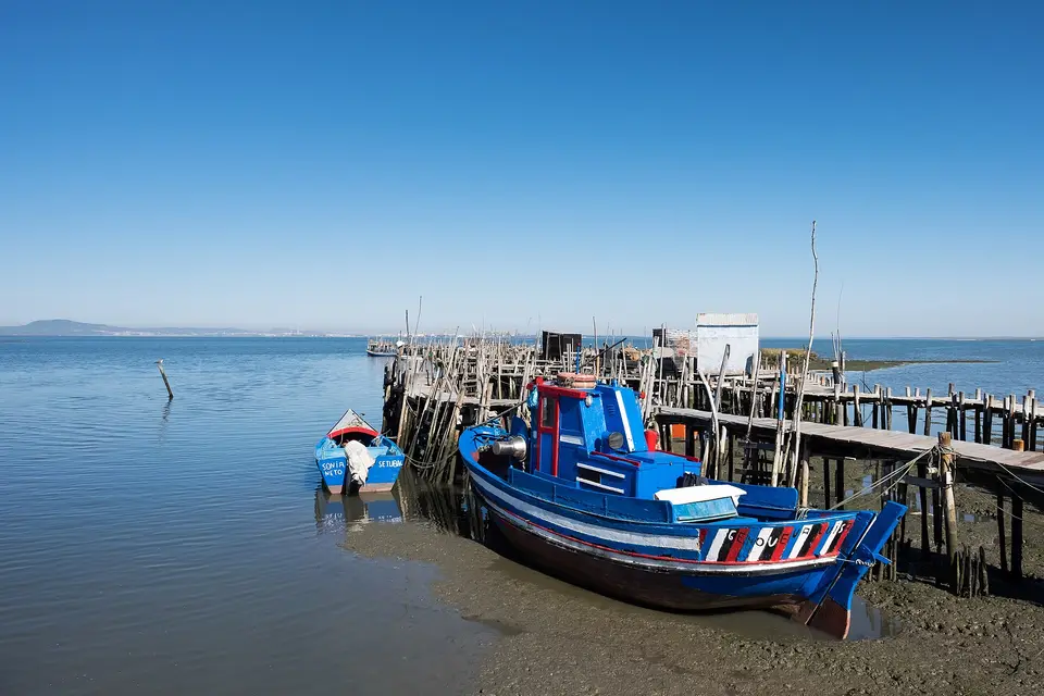 A fishing boat beside the stilted wooden pier of Carrasqueira on the Sado estuary