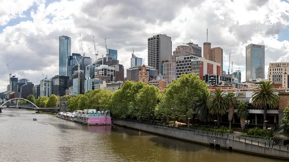 The Melbourne city skyline above the tree-lined Northbank promenade on the Yarra River