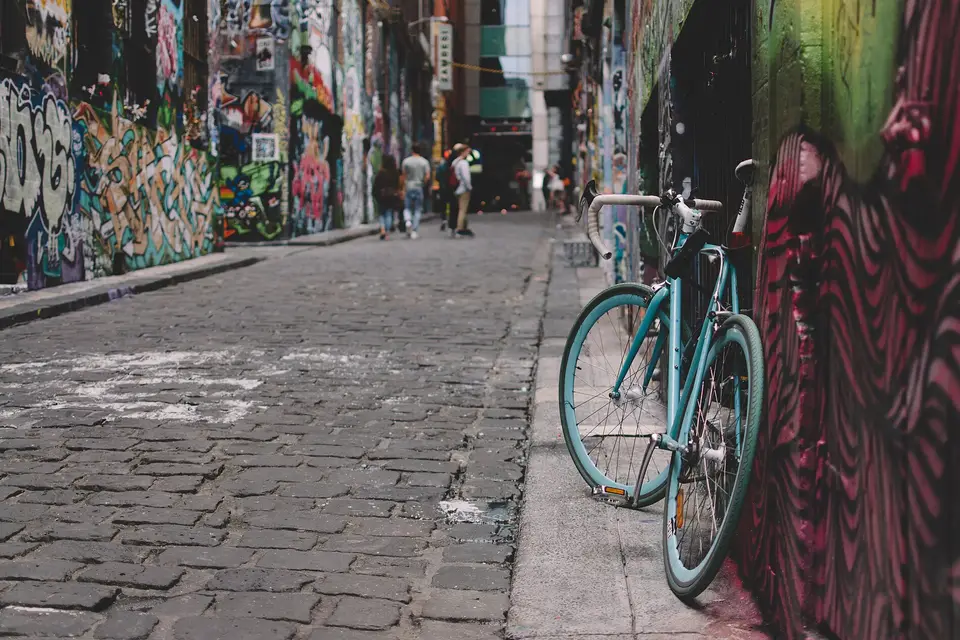 A bicycle leaning on a painted wall in the cobbled, graffiti-covered Hosier Lane in Melbourne