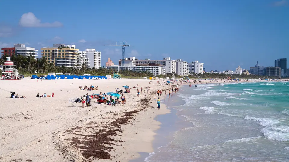 White sand and turquoise surf at the southern tip of Miami Beach, with hotels and palms behind
