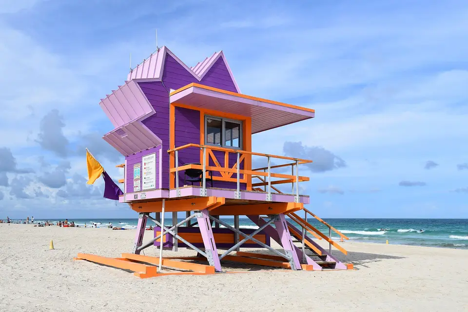 A purple and pink Art Deco lifeguard stand on the sand at South Beach