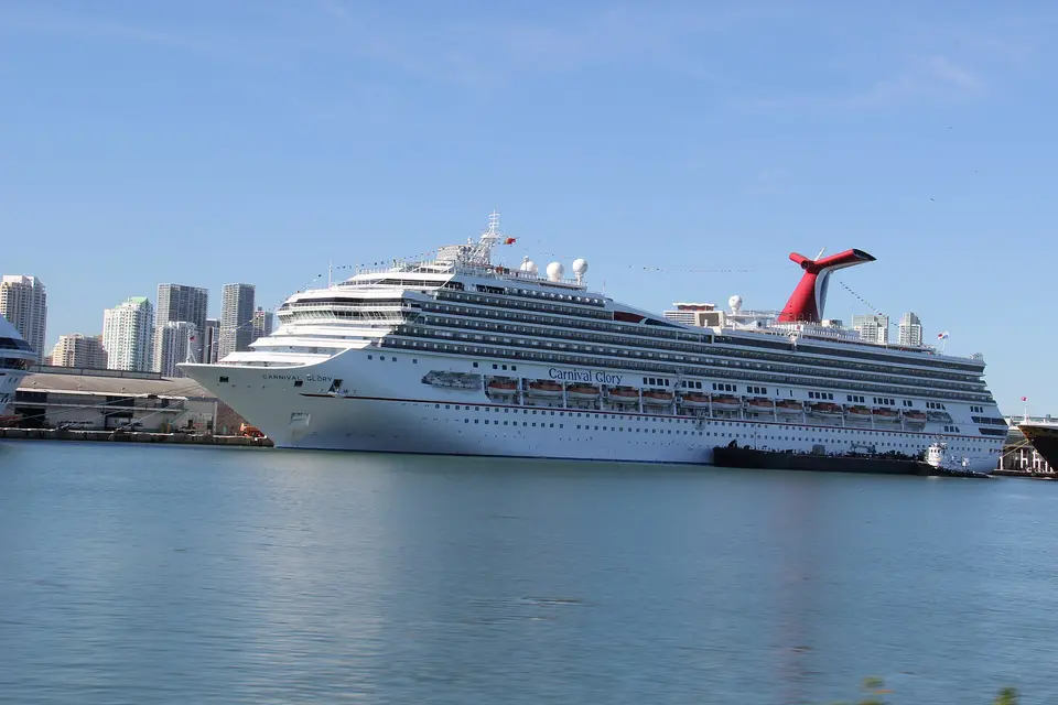 A large cruise ship berthed at PortMiami with downtown towers across the water