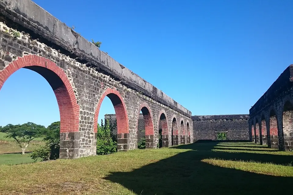 Stone arches of the ruined Belle Mare sugar mill under a clear blue sky