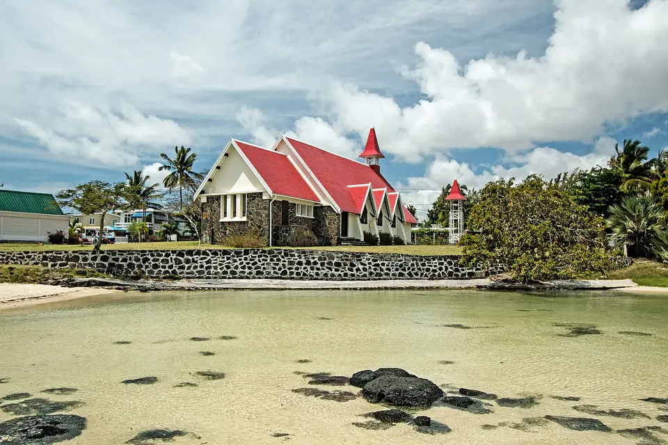 The red-roofed church of Notre-Dame Auxiliatrice behind a shallow lagoon at Cap Malheureux
