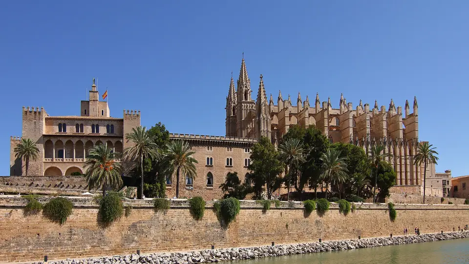 Palma Cathedral and the Almudaina Palace above the old sea wall and lake of Parc de la Mar