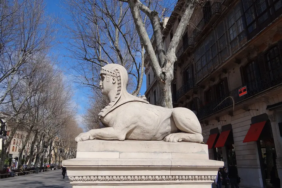 A stone sphinx on the tree-lined Passeig des Born in central Palma