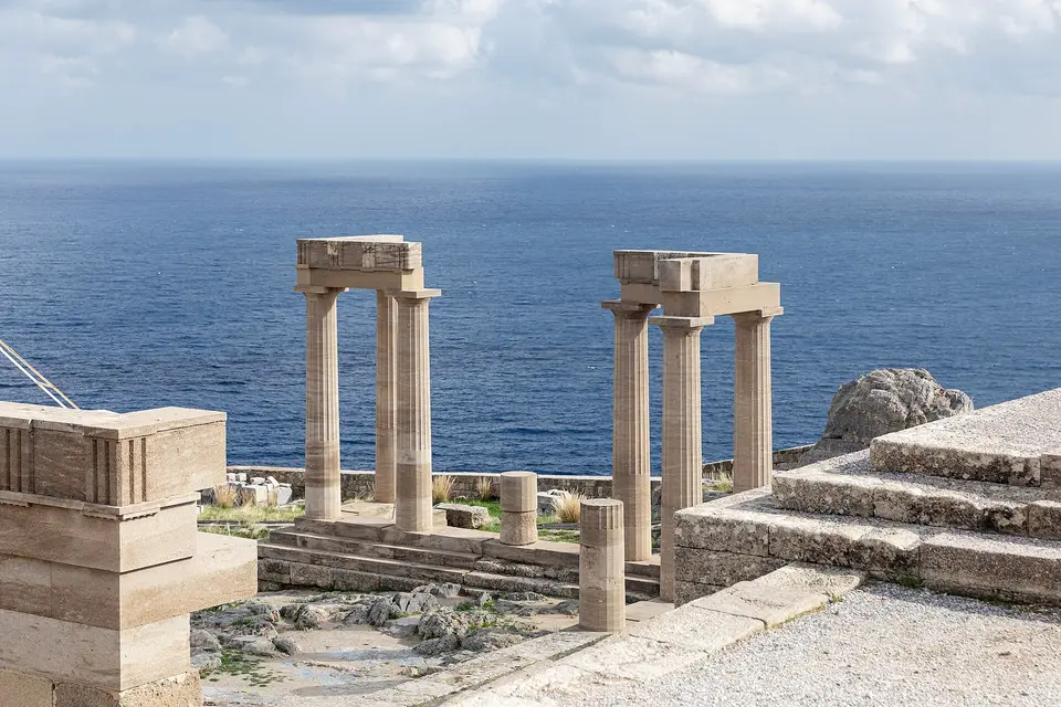 Restored stone columns on the acropolis of Lindos standing above the open sea