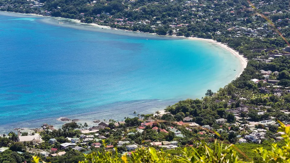 The turquoise curve of Beau Vallon bay and its wooded shore, seen from the hills above