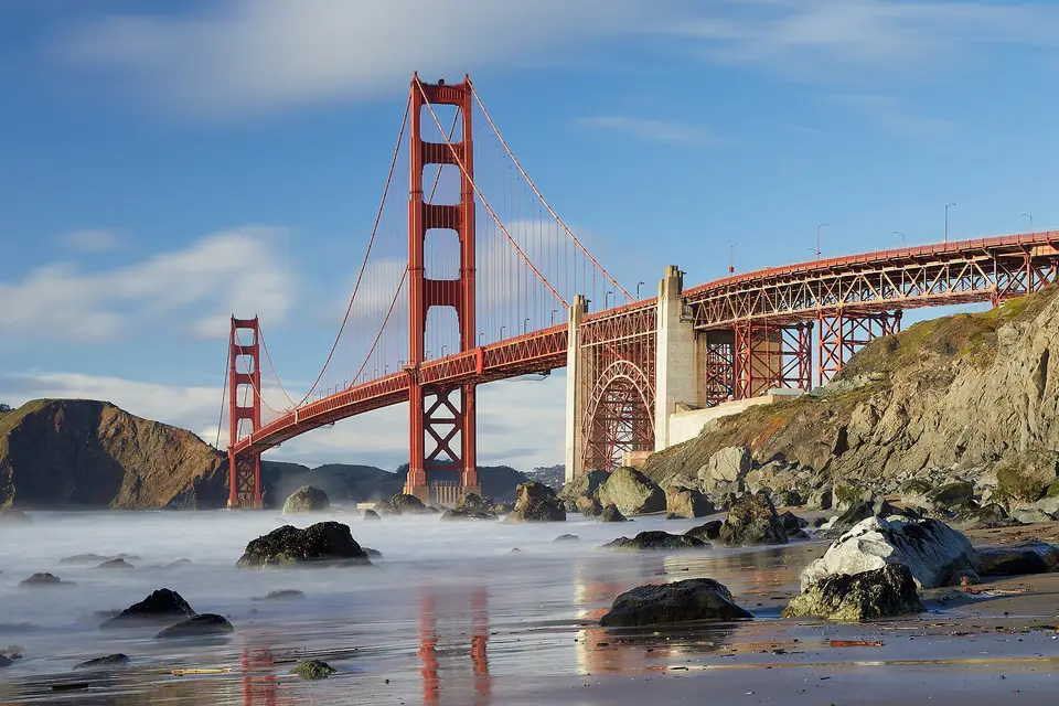 The Golden Gate Bridge above the rocks and surf of Marshall's Beach, San Francisco
