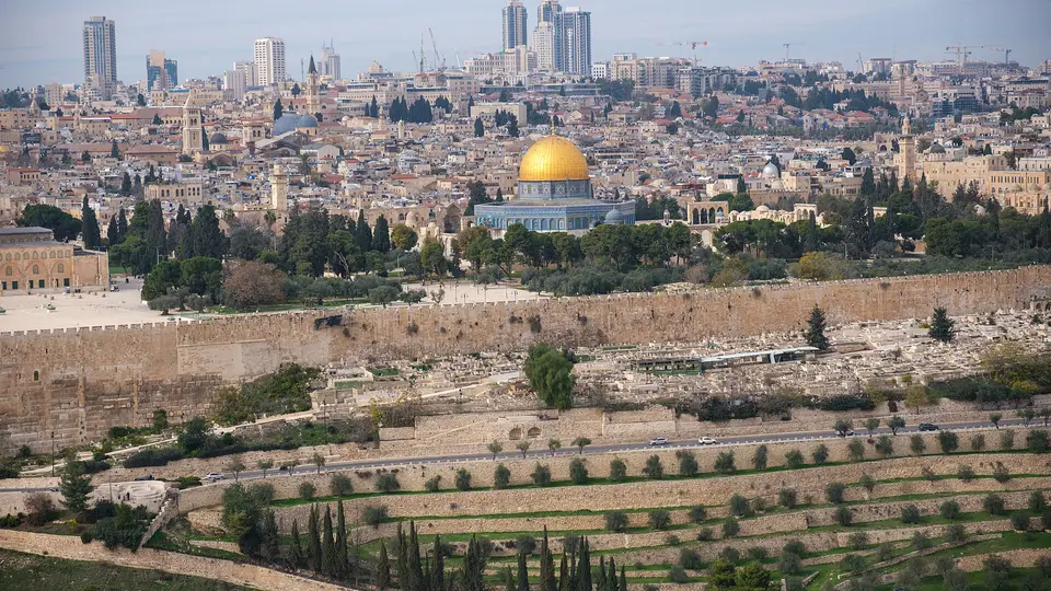 Jerusalem's Old City walls and golden-domed skyline seen across olive terraces from the Mount of Olives