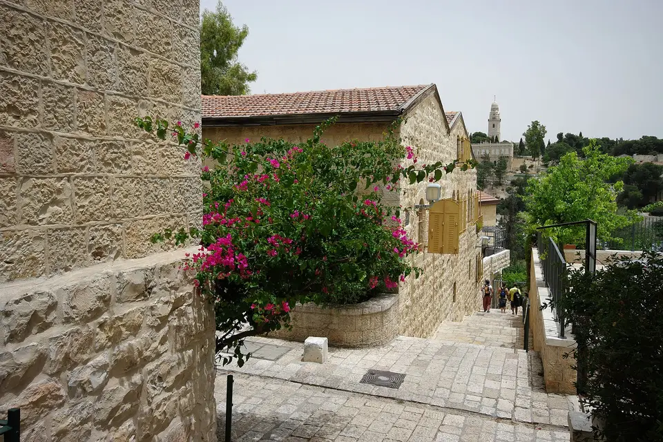 A stone-paved lane with flowering bougainvillea between old houses in Yemin Moshe, Jerusalem
