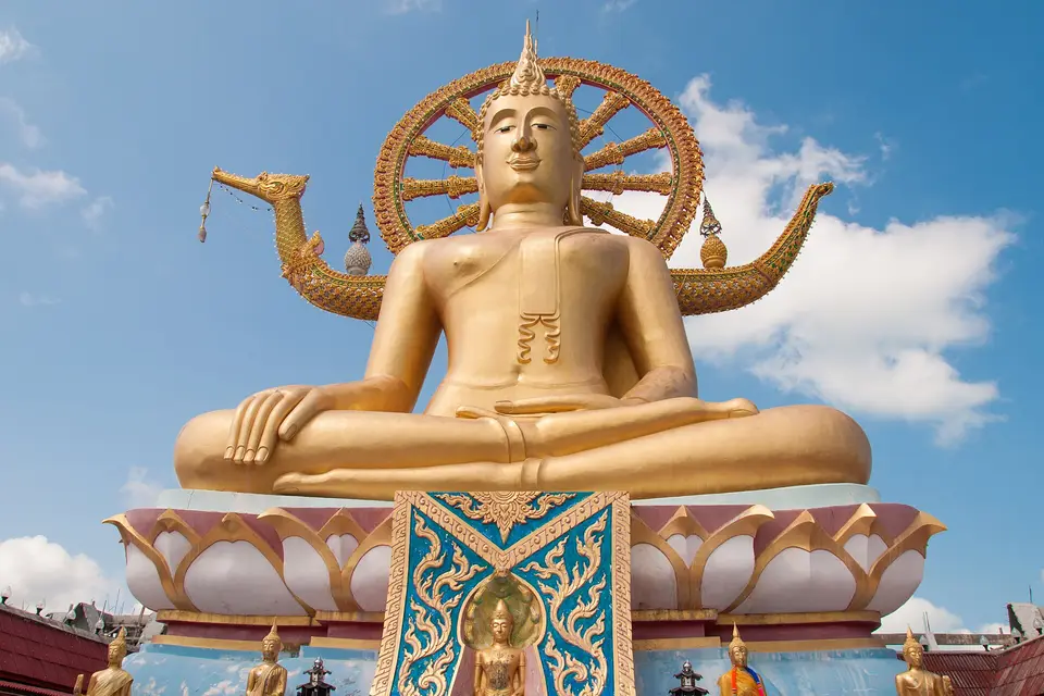 The golden Big Buddha statue of Wat Phra Yai on Koh Samui against a blue sky